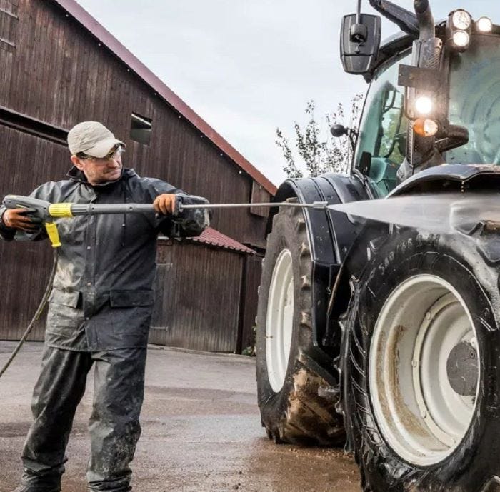Kärcher Hochdruckreiniger für die Landwirtschaft Mann mit Kärcher Hochdruckreiniger reinigt Traktor